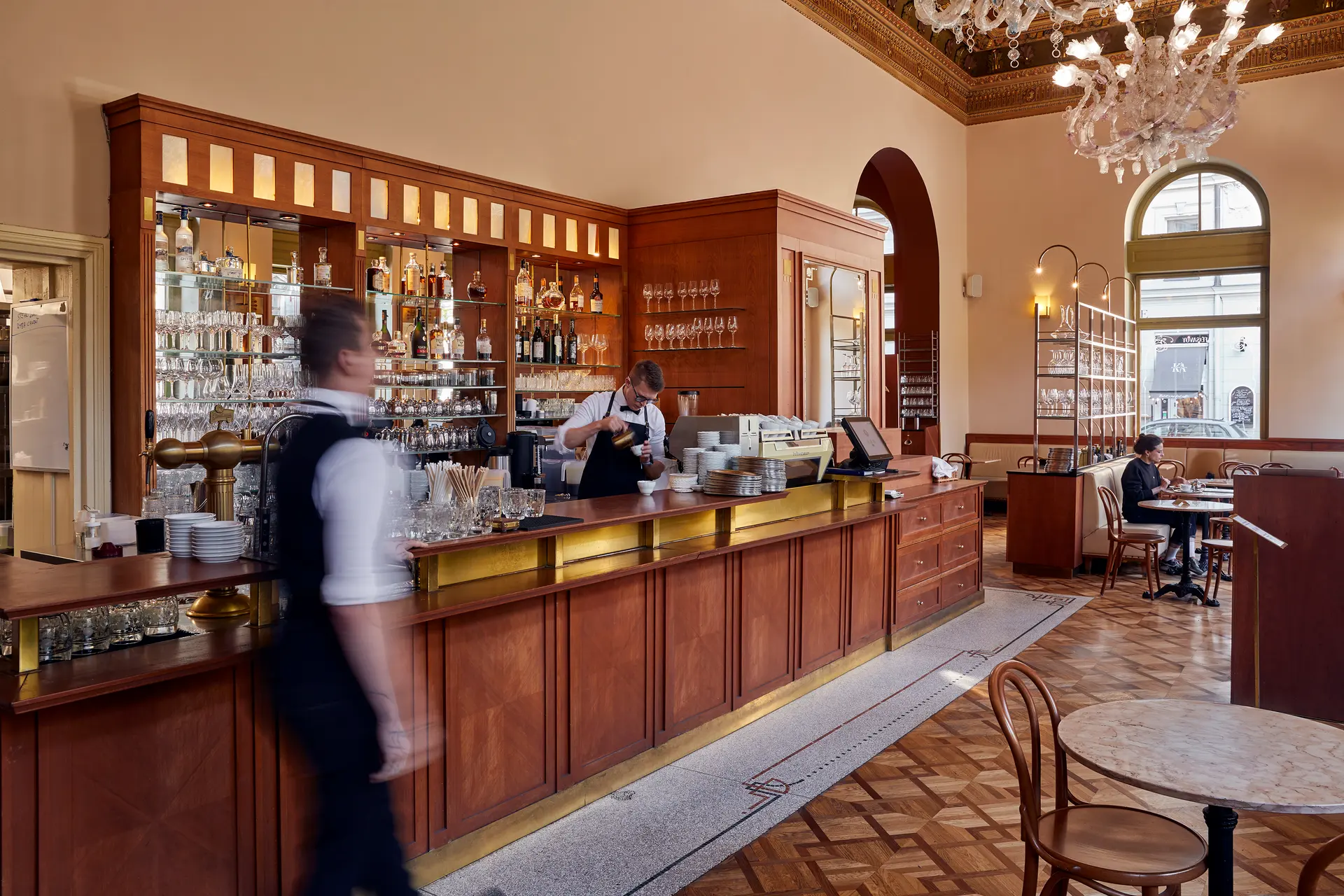 Bar a interiér restaurace a kavárny Savoy s obsluhou v pohybu.